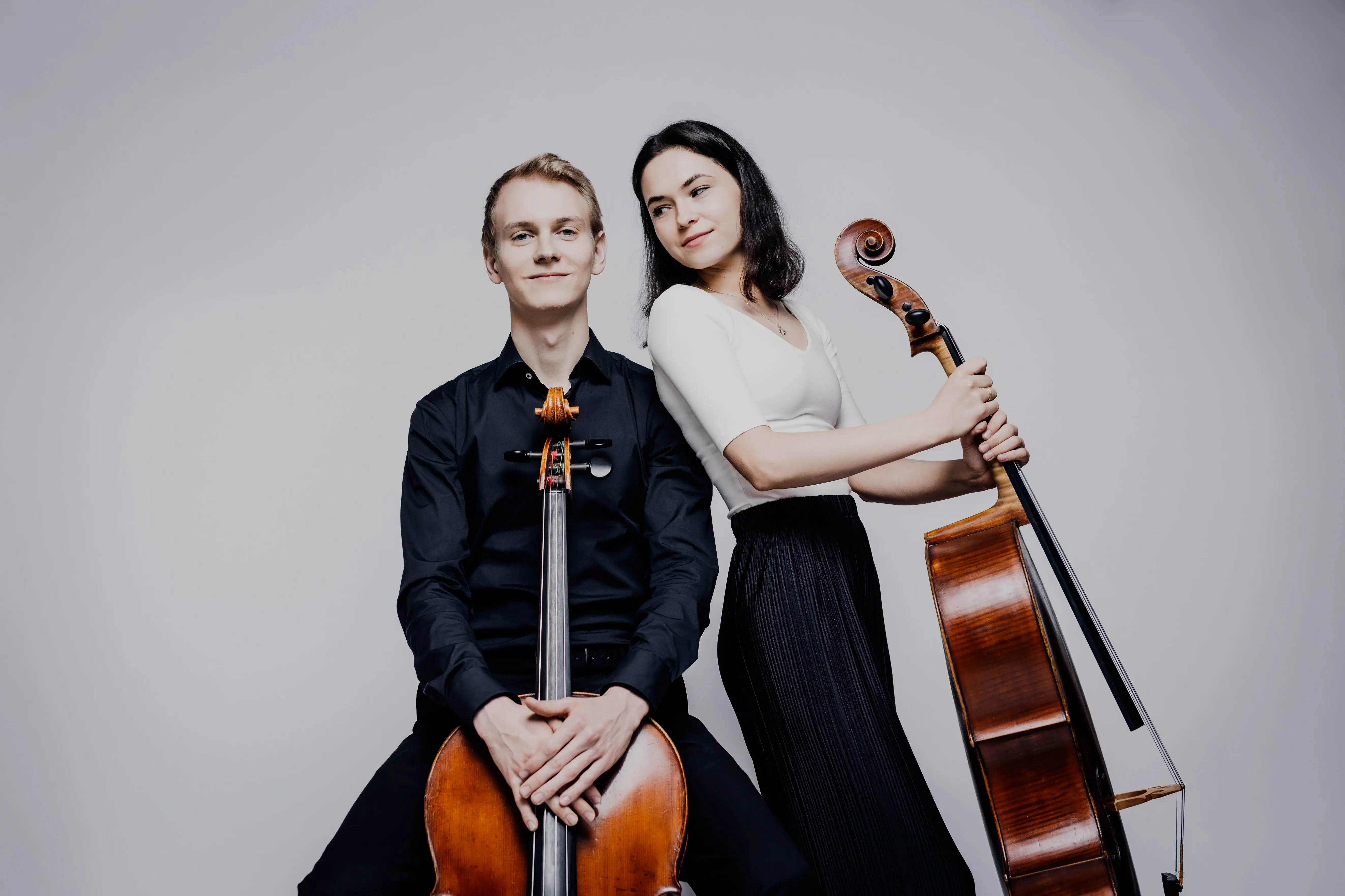 Cello Duo Ein Mann und eine Frau posieren mit zwei Celli.