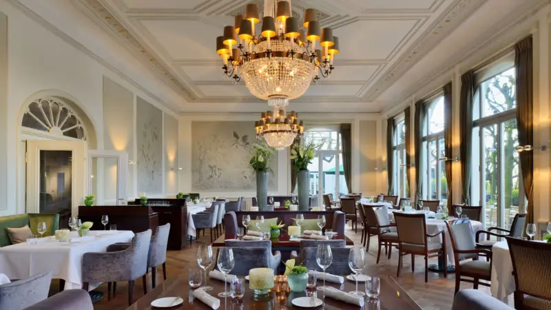 Jacobs Restaurant Das Jacobs Restaurant mit Tischen und Stühlen, dekoriert mit Kronleuchtern.