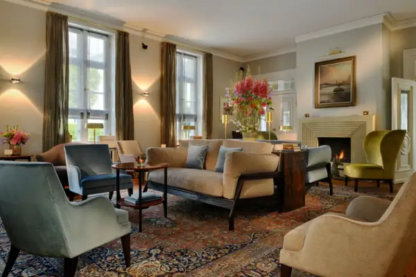 Wohnhalle Wohnhalle des Hotels Louis C. Jacob mit gemütlichen Sesseln, Sofas und einem Kamin.