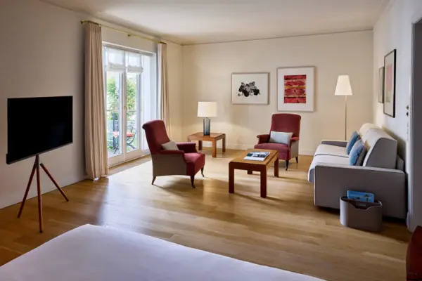 Studio Louis C. Jacob Hotel Hamburg Ein großes Hotelzimmer mit einem Bett und einem Sofa.