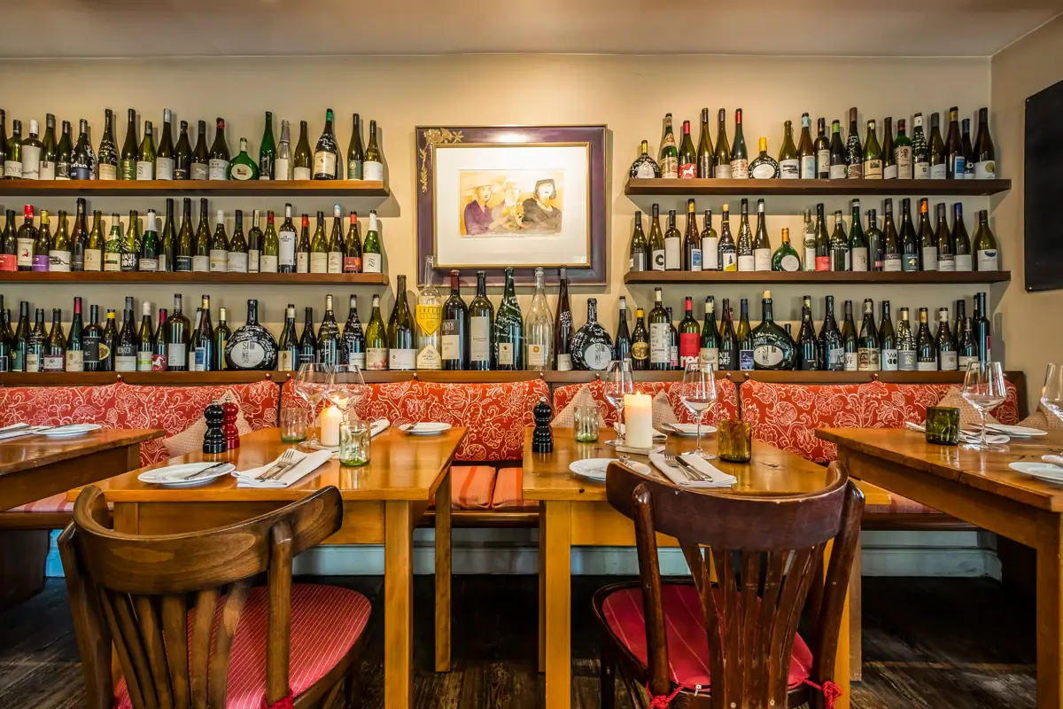 Ein Tisch mit Weinflaschen an der Wand.