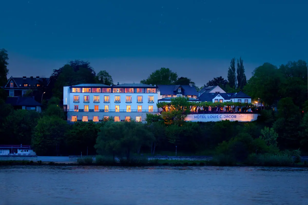 Louis C. Jacob Beleuchtetes Haus hinter einem Fluss