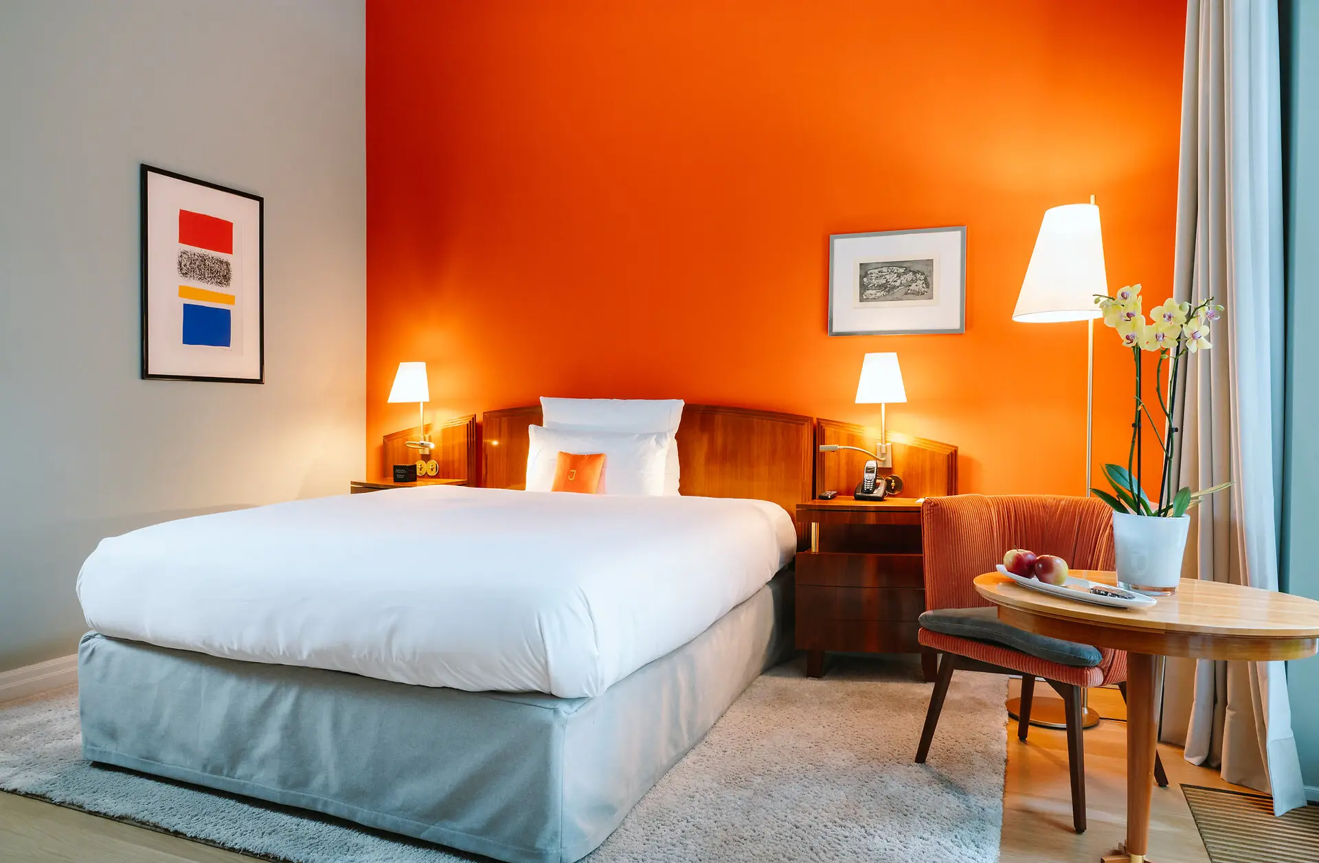 Einzelzimmer Louis C. Jacob Hotel Hamburg Ein Bett in einem Hotelzimmer mit orangefarbenen Wänden.