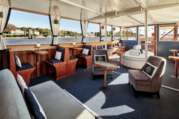 MS Jacob Innenraum Der Innenraum der Barkasse MS Jacob mit Sitzbänken und Kissen und großen Fenstern, wodurch der Hamburger Hafen zu sehen ist.