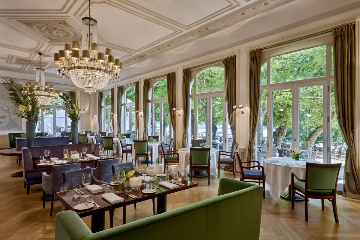 Jacobs Restaurant Restaurant mit gedeckten Tischen und Kronleuchtern.