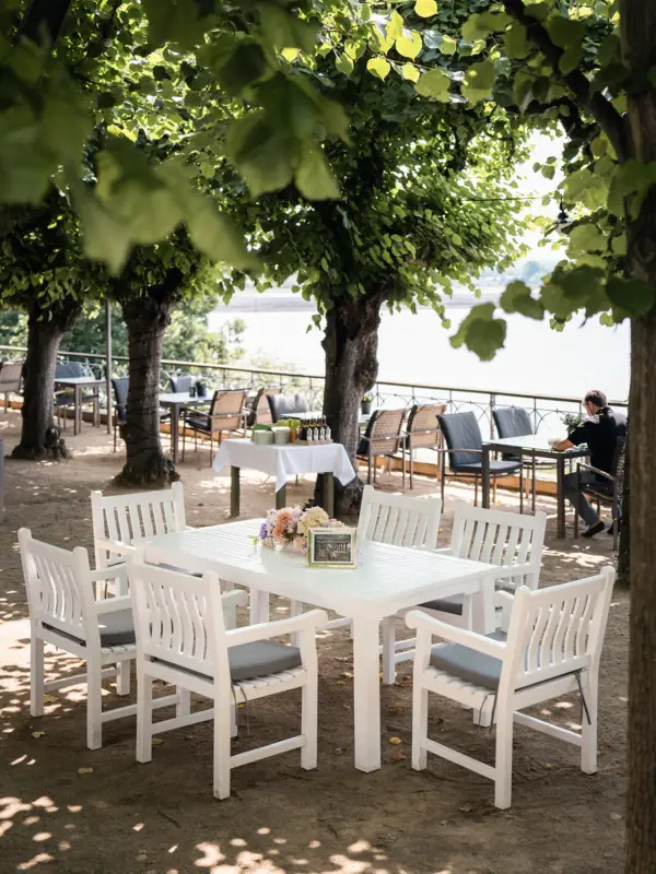 Lindenterrasse Der Liebermanntisch auf der Lindenterrasse unter Bäumen.