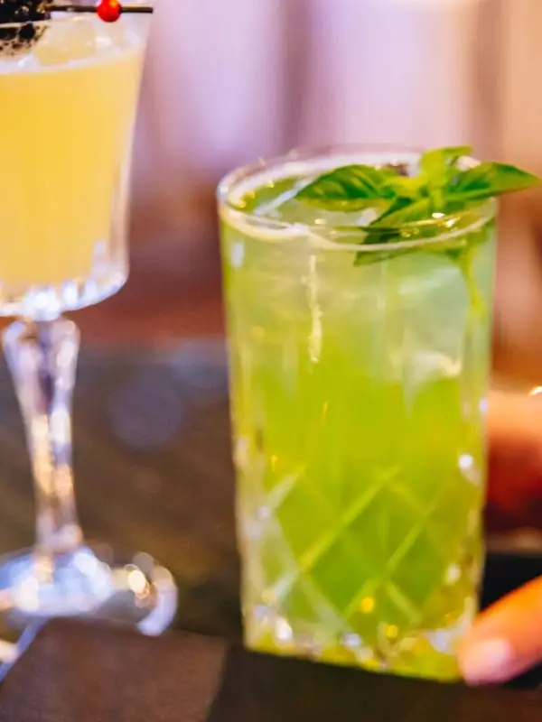 Drinks Cocktailgläser mit gelben und grünen Flüssigkeiten.