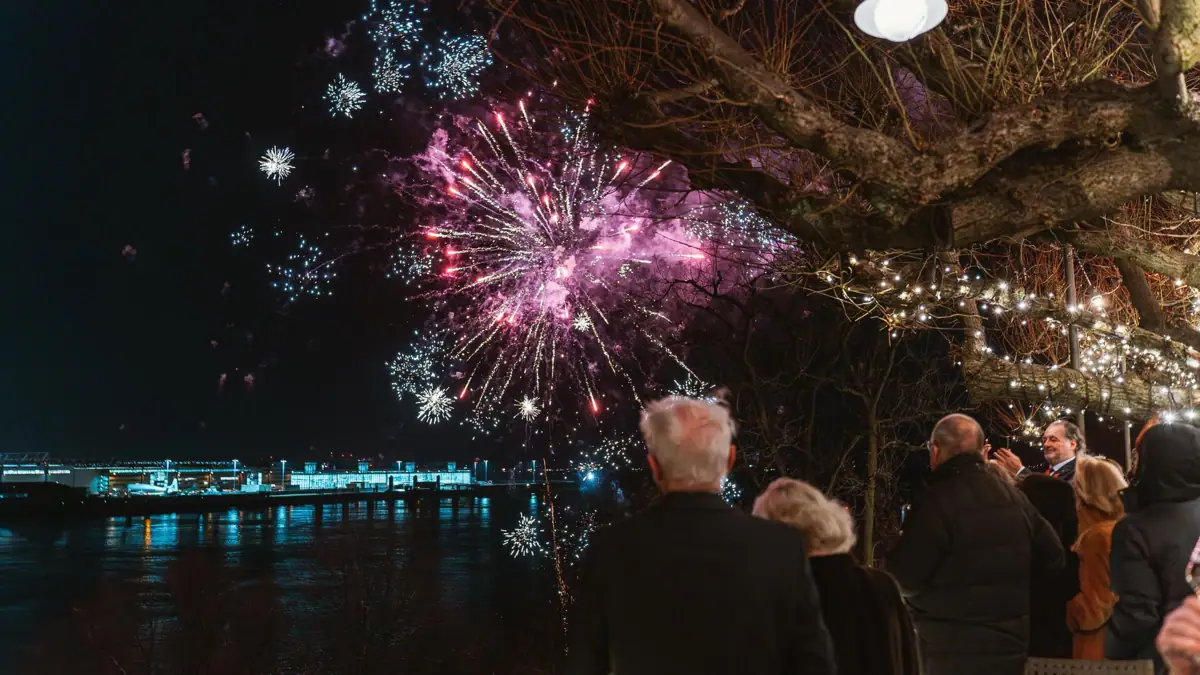 Silvester im Jacob Eine Gruppe von Menschen betrachtet ein Feuerwerk.