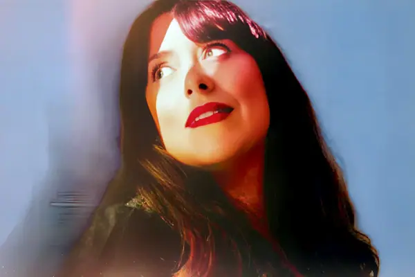 Véronique Elling Eine Frau mit langen Haaren schaut zur Seite und ihr Gesicht wird mit Licht und Schatten angestrahlt.