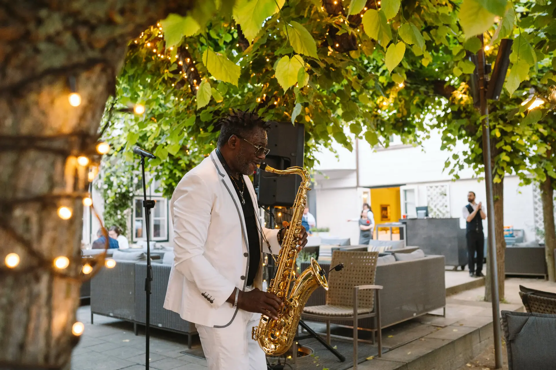 Events Louis C. Jacob Hamburg Ein Mann spielt Saxophon unter einem Baum.