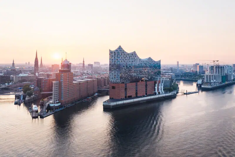 Stadtansicht mit Wasserweg und Schiffen im Vordergrund.