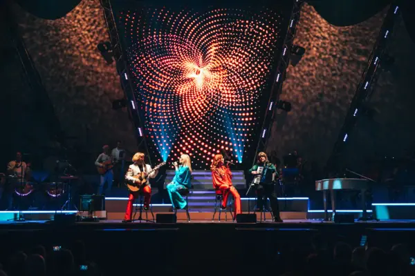 Abbamania in Hamburg Eine Gruppe von Menschen auf einer Bühne bei einem Konzert.