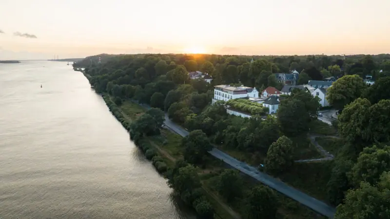 Angebote & Arrangements Gewässer mit Gebäuden und Bäumen im Hintergrund