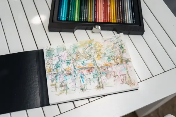 Zeichnung Skizzenbuch mit Buntstiften auf einem Tisch