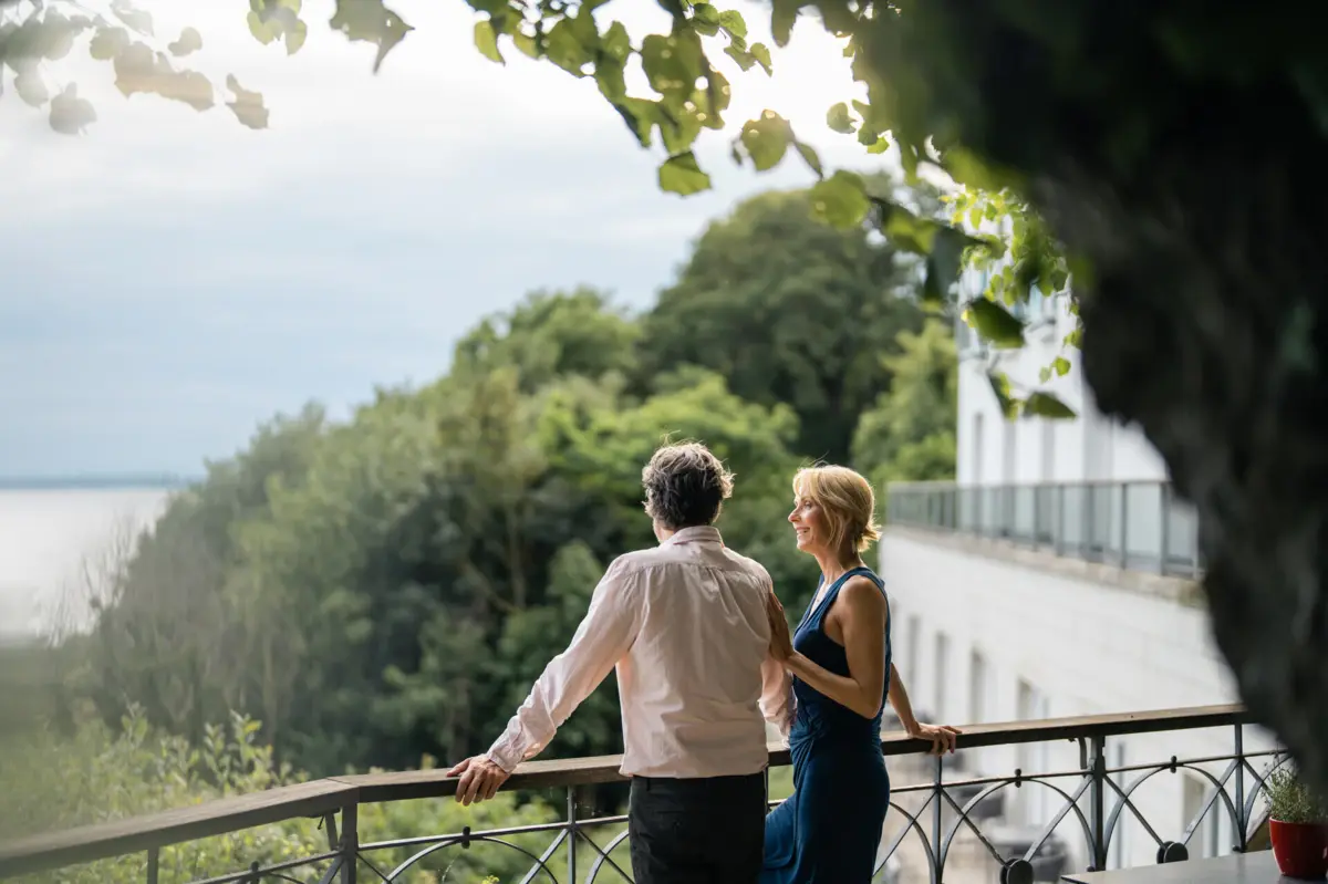 Ausblick Lindenterrasse Ein Mann und eine Frau stehen an der Reling der Lindenterrasse des Hotels Louis C. Jacob und schauen auf die Elbe.
