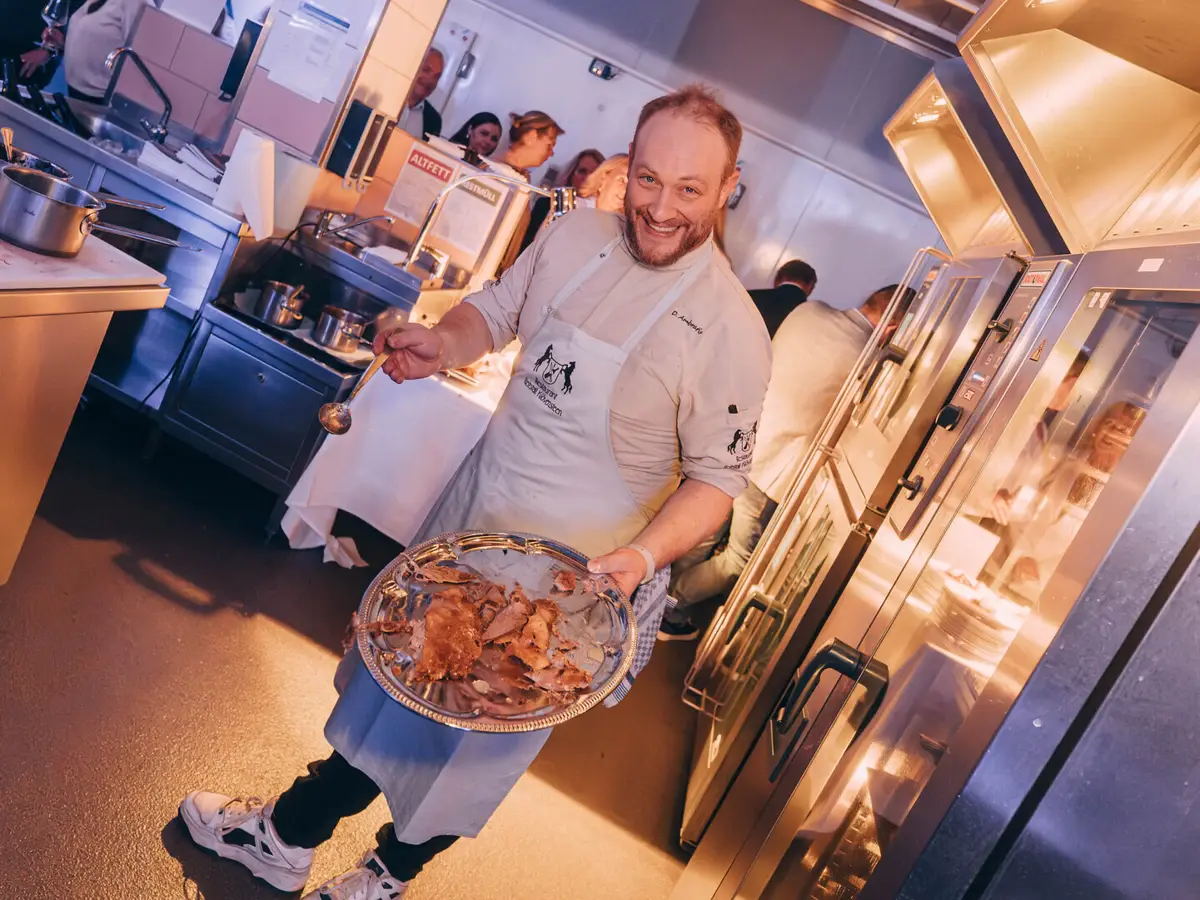 Der Gastkoch Daniel Sören Ambratis aus dem Restaurant "Reistall Klövensteen" präsentiert eine Platte mit Entenfleisch.