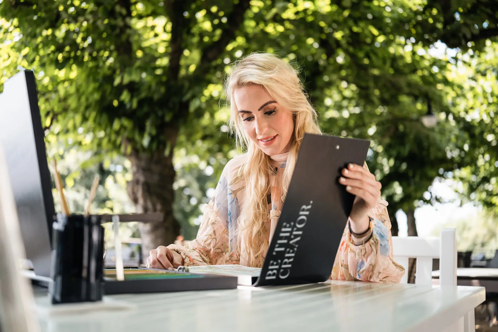 Eine Frau sitzt an einem Tisch und liest eine Speisekarte.