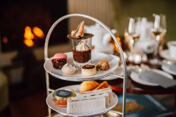 Afternoon Tea Etagere Etagere gefüllt mit herzhaften und süßen Köstlichkeiten vor dem Kamin in der Wohnhalle des Hotels Louis C. Jacob.