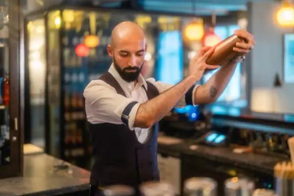 Barkeeper Barkeeper mixt einen Cocktail in einem Shaker in der Luft.