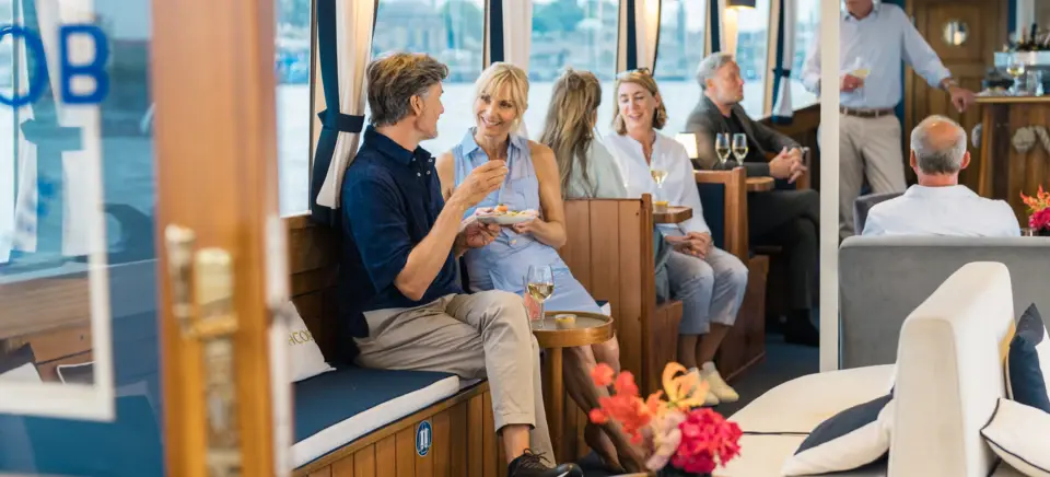 Eine Gruppe von Menschen sitzt auf einem Boot und isst.